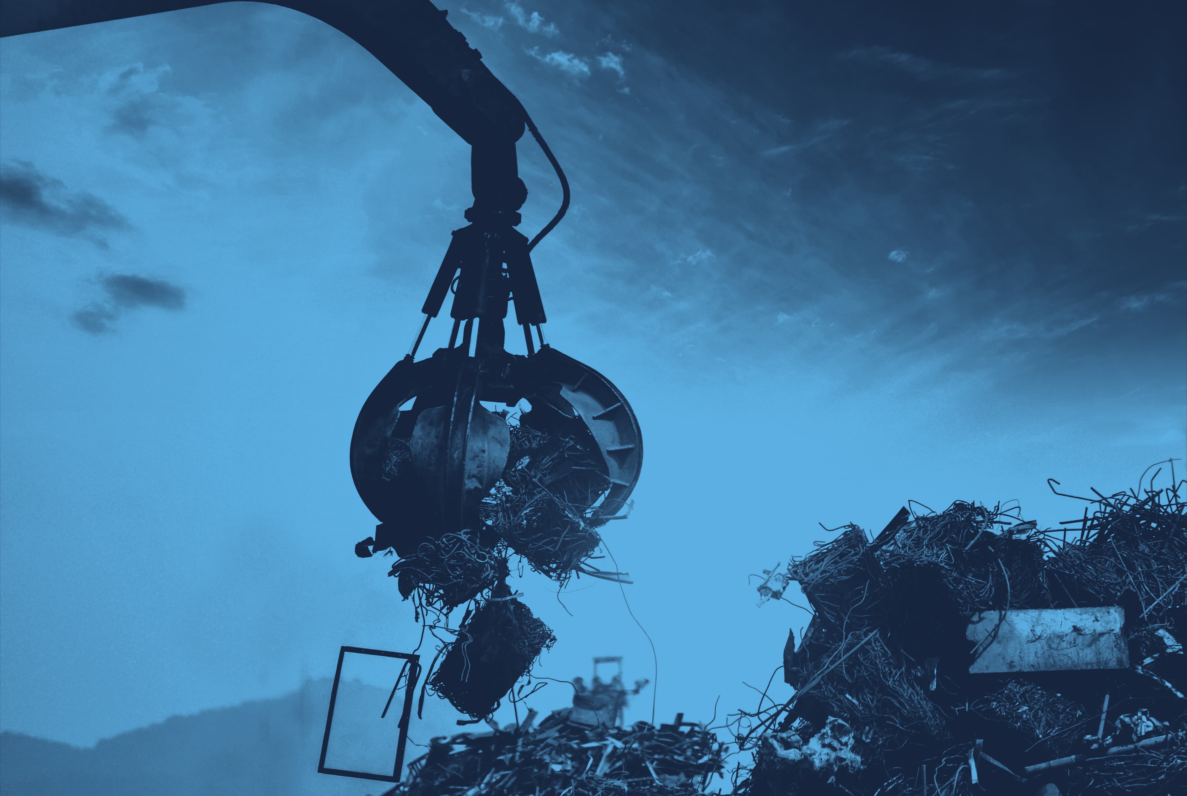 Machine collecting scrap metal from a scrap yard