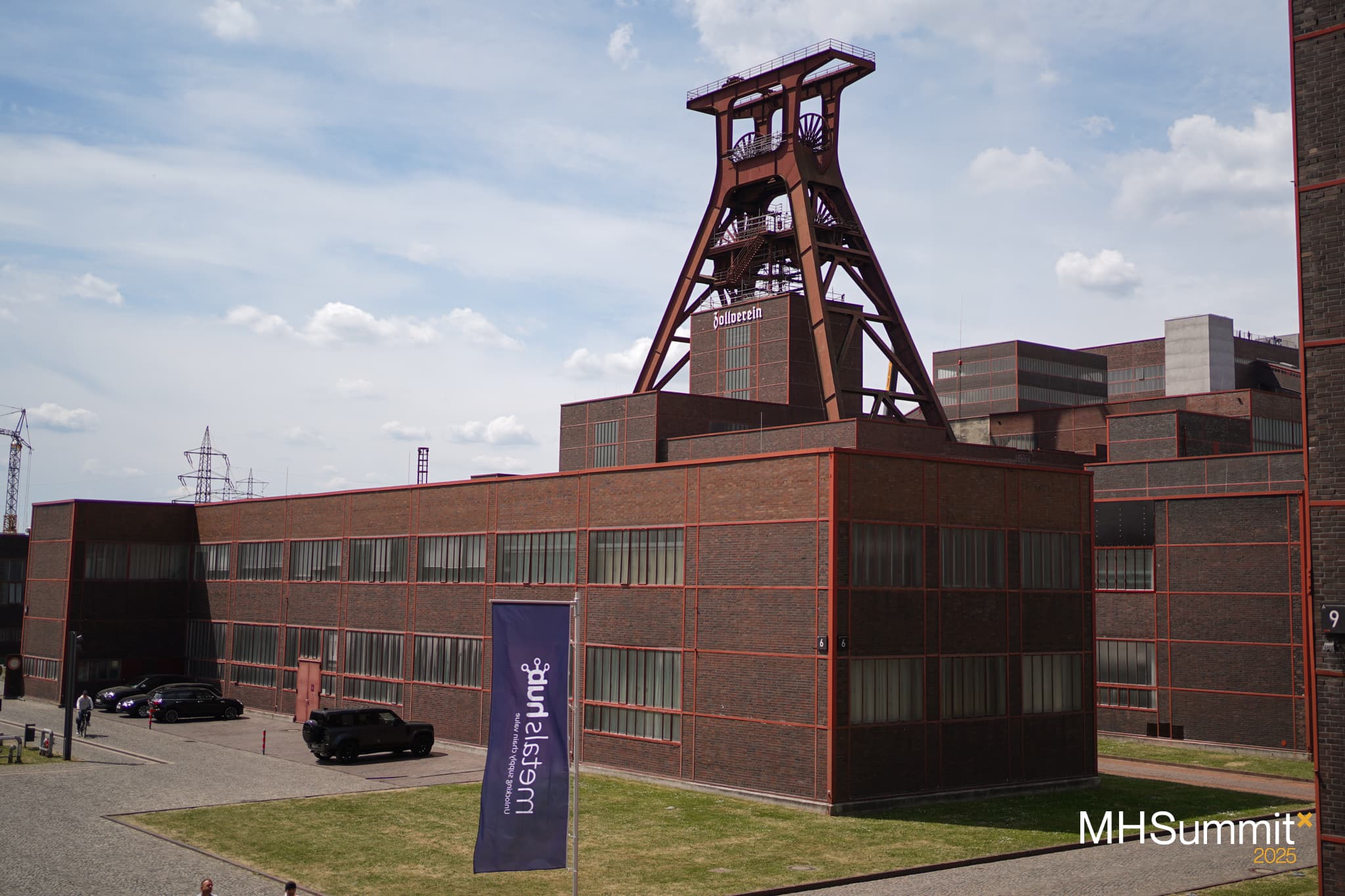 The Zeche Zollverein with the Metalshub flag in the foreground showing the location of the Metalshub Summit 2025