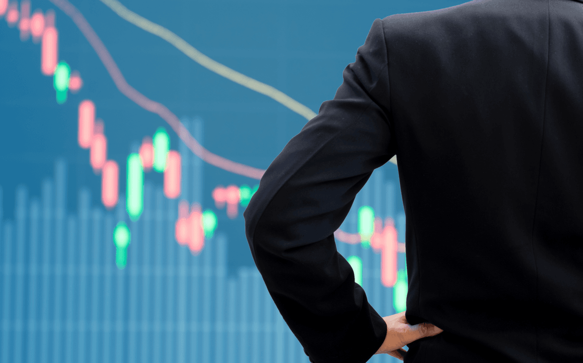 Image of a man standing in front of market trading data