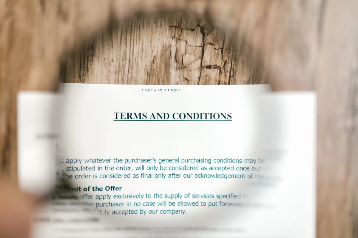 A document titled Terms and Conditions under a magnifying glass