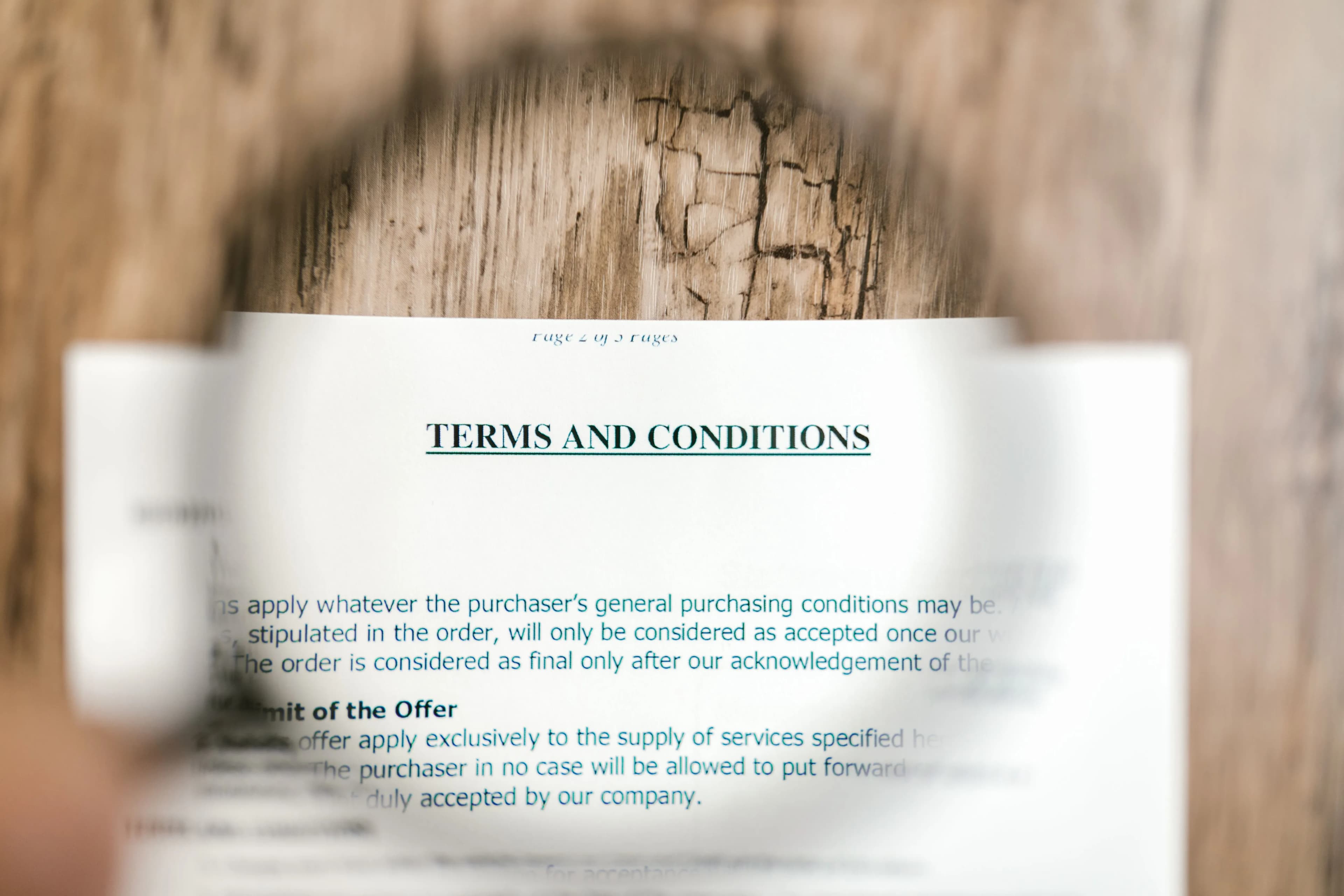 A document titled Terms and Conditions under a magnifying glass